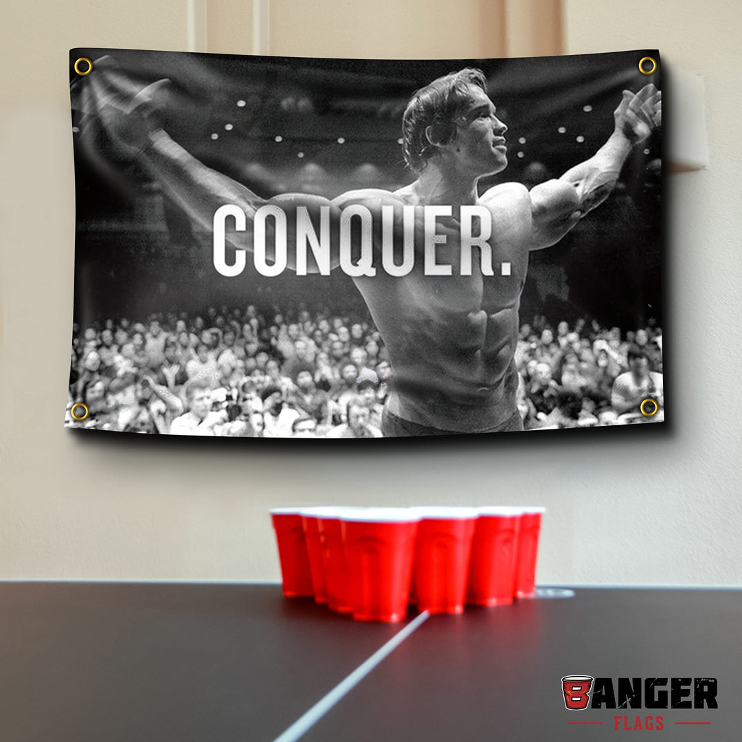 Banger - Original Arnold Schwarzenegger Conquer Motivational Inspirational Office Gym Dorm Wall Decor Design on a 3X5 Feet Flag with 4 Grommets for Easy Hanging. Authentic BANGER FLAG